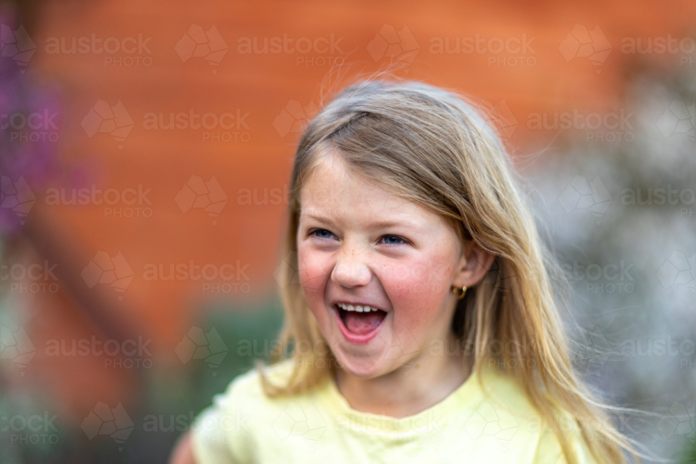 Child laughing joyfully during outdoor playtime - Australian Stock Image