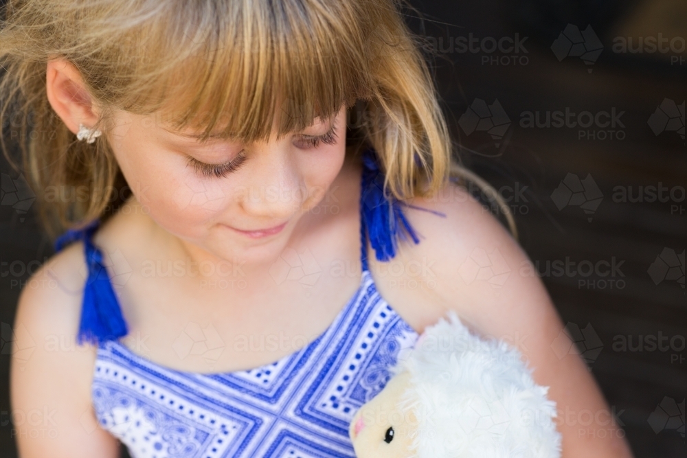 Child looking at her soft toy - Australian Stock Image