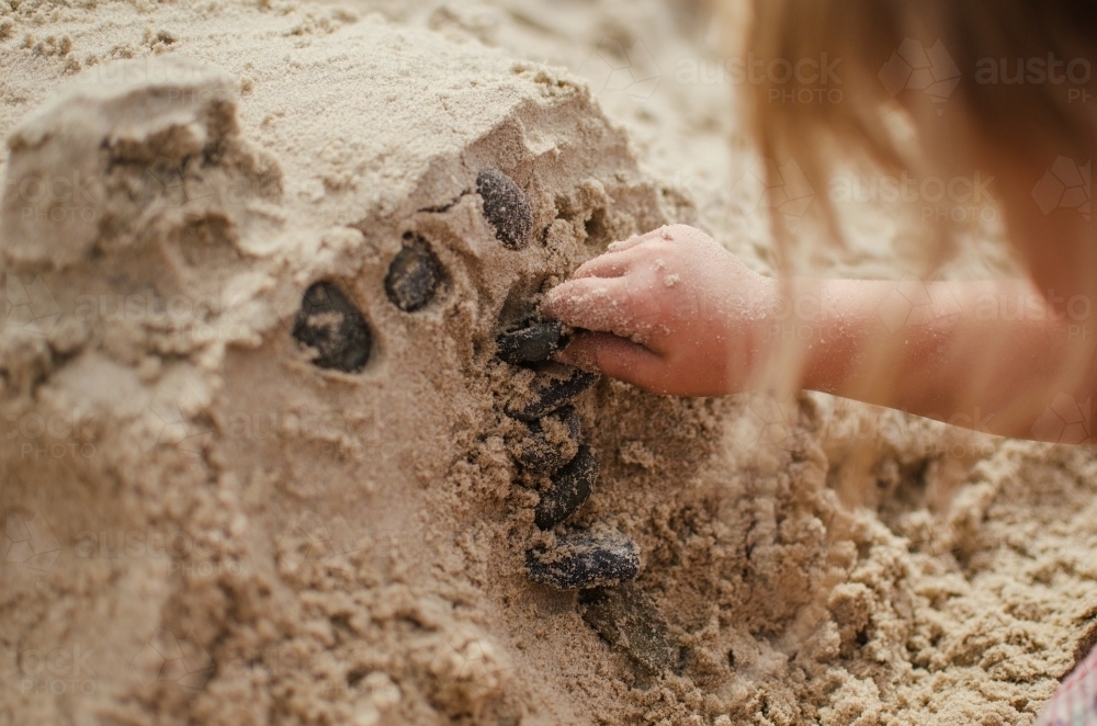 Child making sandcastles - Australian Stock Image