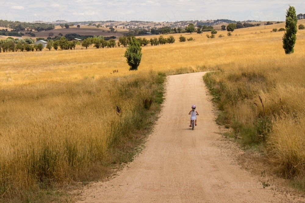 Child on a bike in fields - Australian Stock Image