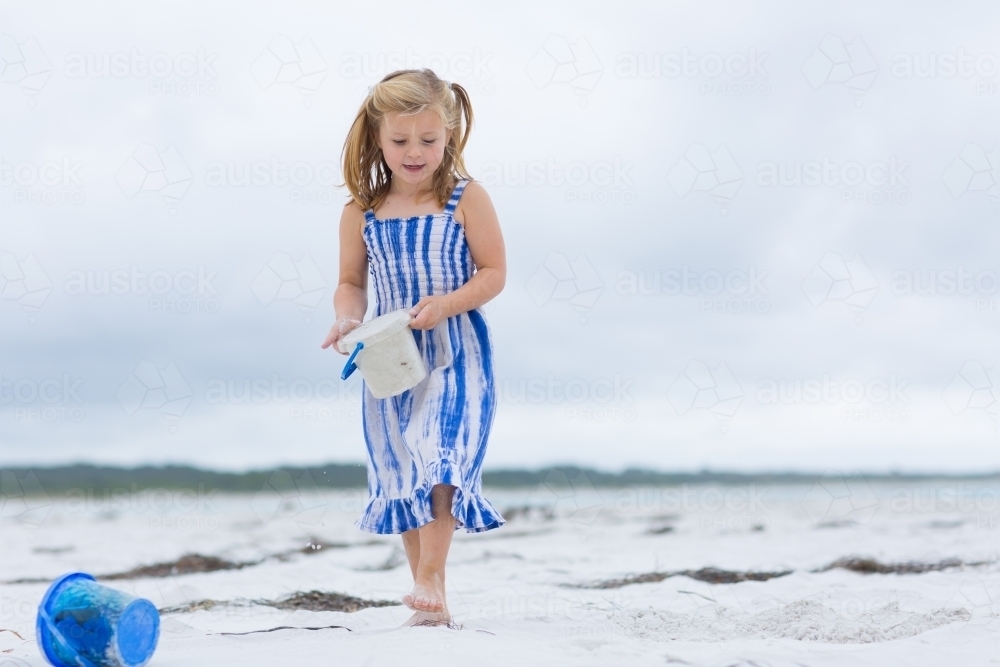 Child on the beach with buckets - Australian Stock Image