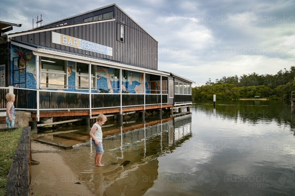 Child paddling in water beside Fisherman's Wharf at Woy Woy - Australian Stock Image