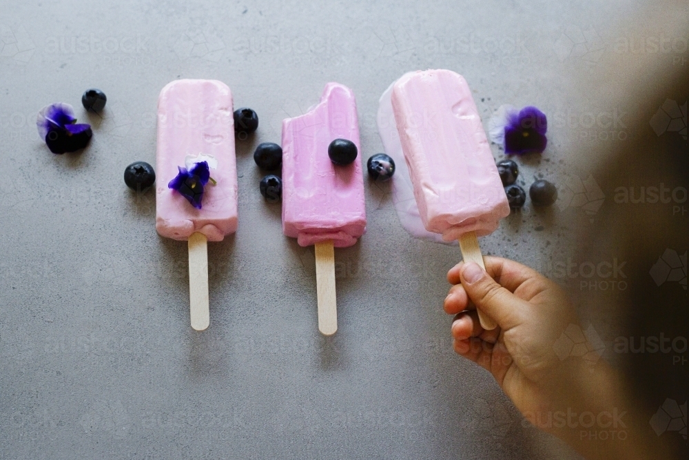 Child picking up ice cream - Australian Stock Image