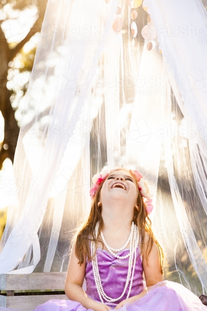 Child playing princess dress ups in afternoon light - Australian Stock Image