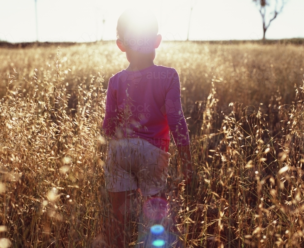 Child Running in Summertime through grass - Australian Stock Image