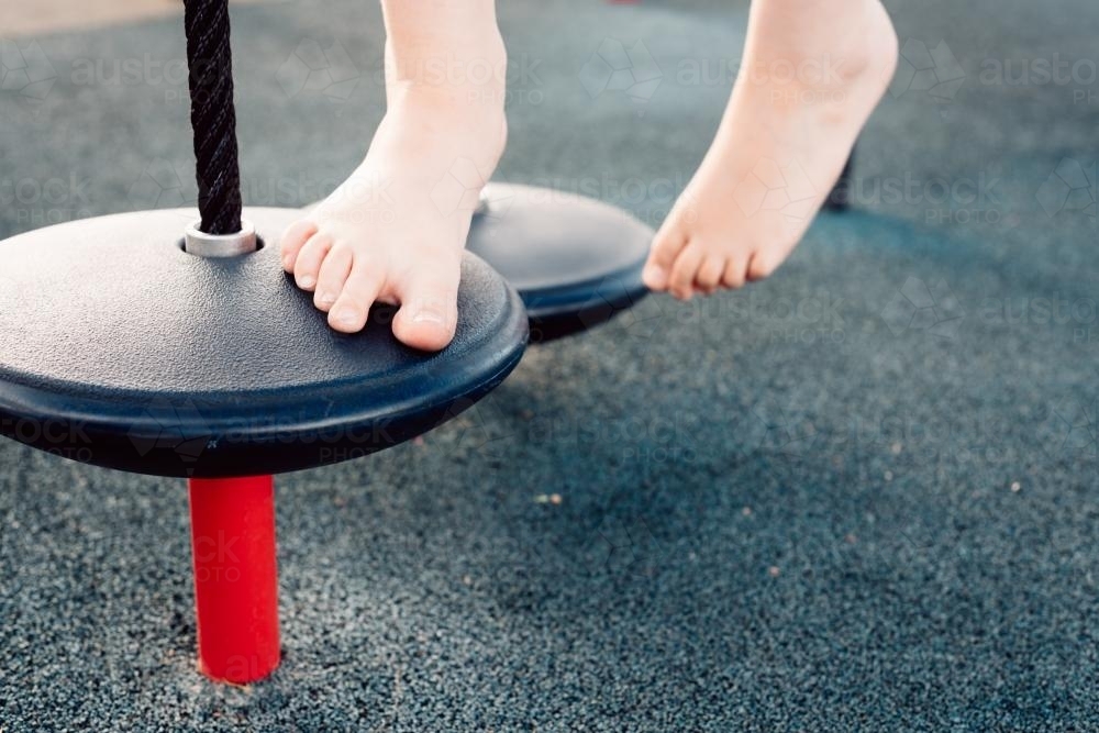 child's feet on playground equipment - Australian Stock Image