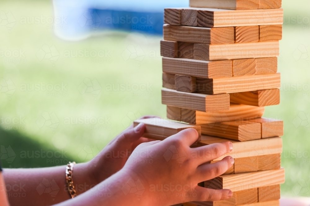 Hand Stack Game Image of Child's hands playing block stacking puzzle game - Austockphoto