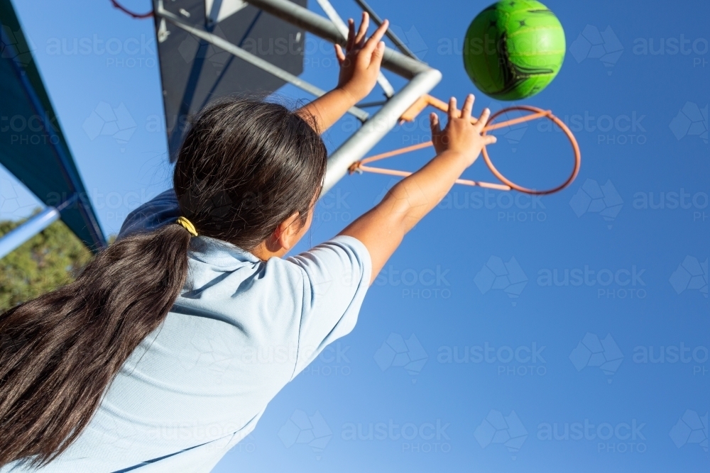 Child shooting netball goal - Australian Stock Image