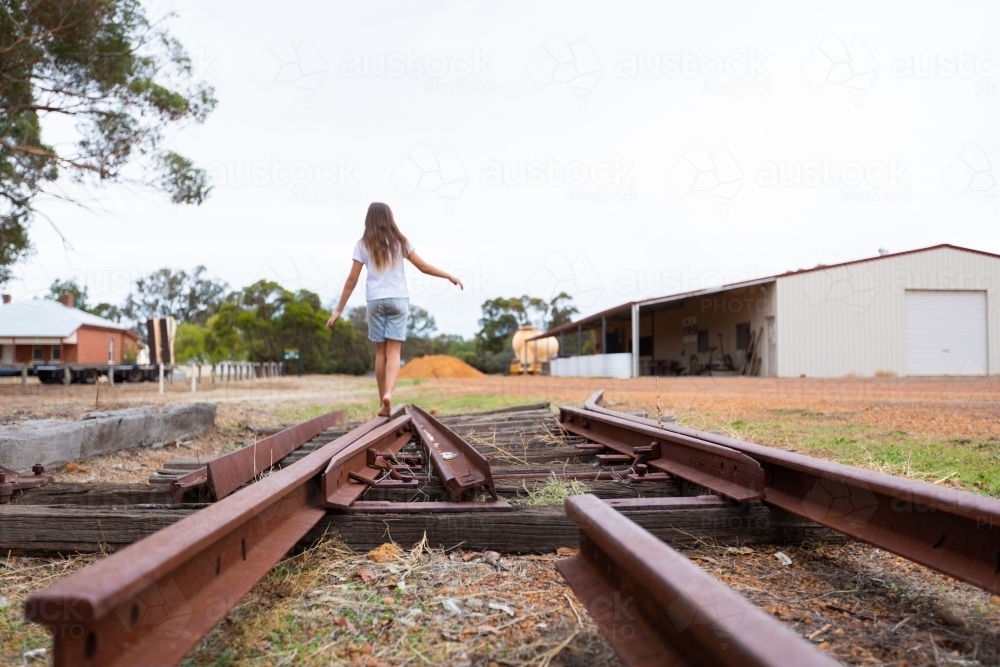 child walking along old disused railway track - Australian Stock Image