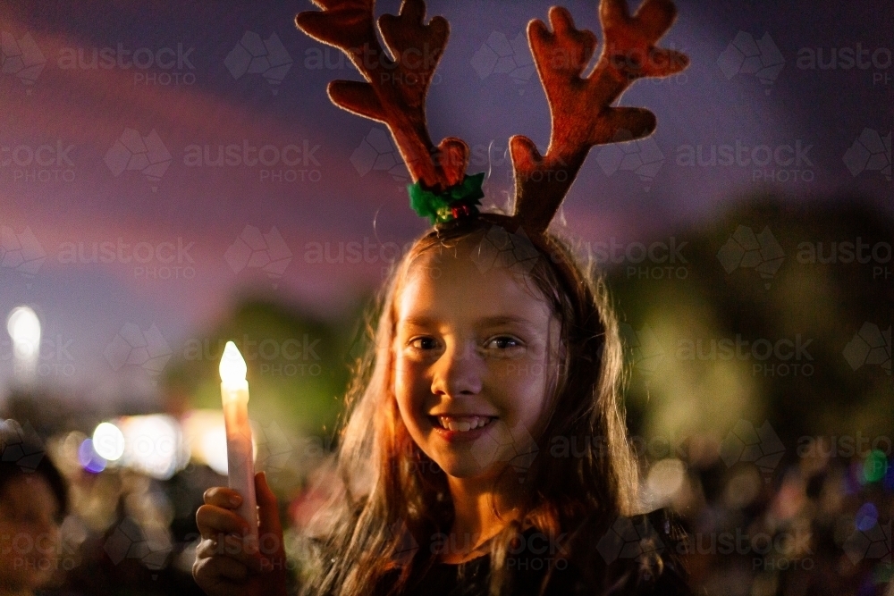 child wearing Christmas antlers for carols by candlelight - Australian Stock Image
