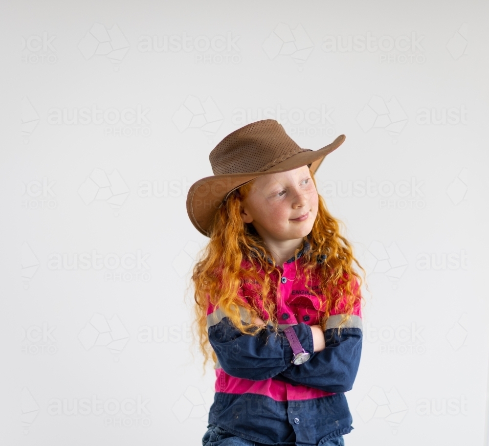 child wearing hi-vis work shirt and cowboy hat with arms crossed - Australian Stock Image