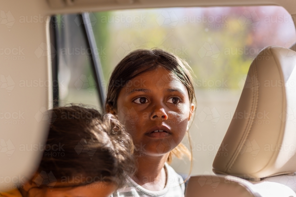 child with dirty face sitting in back seat of a car - Australian Stock Image
