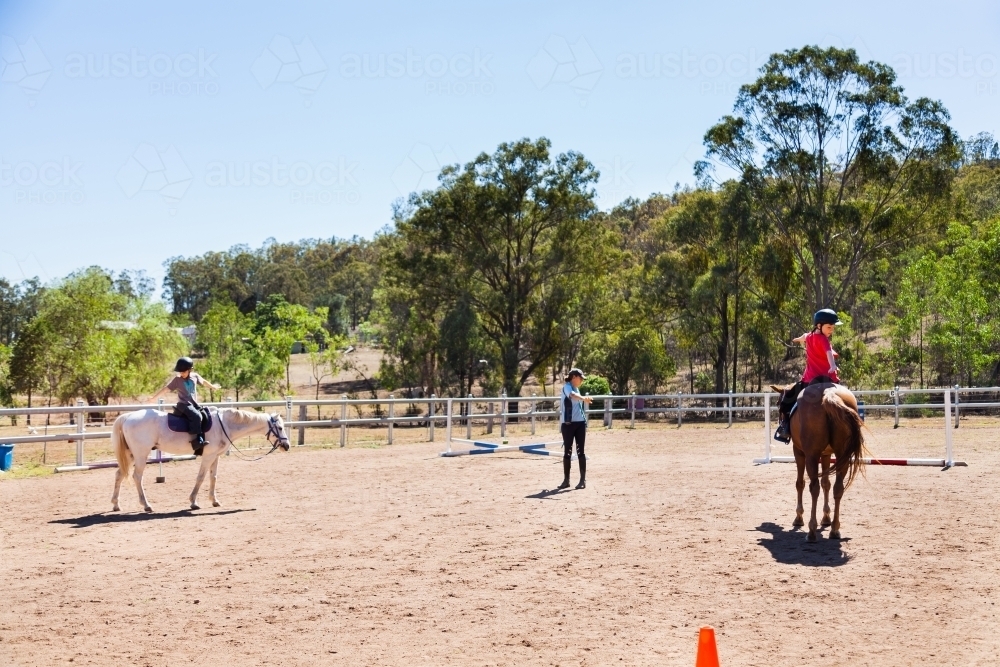 Image of Children doing stretches during riding lesson with instructor ...