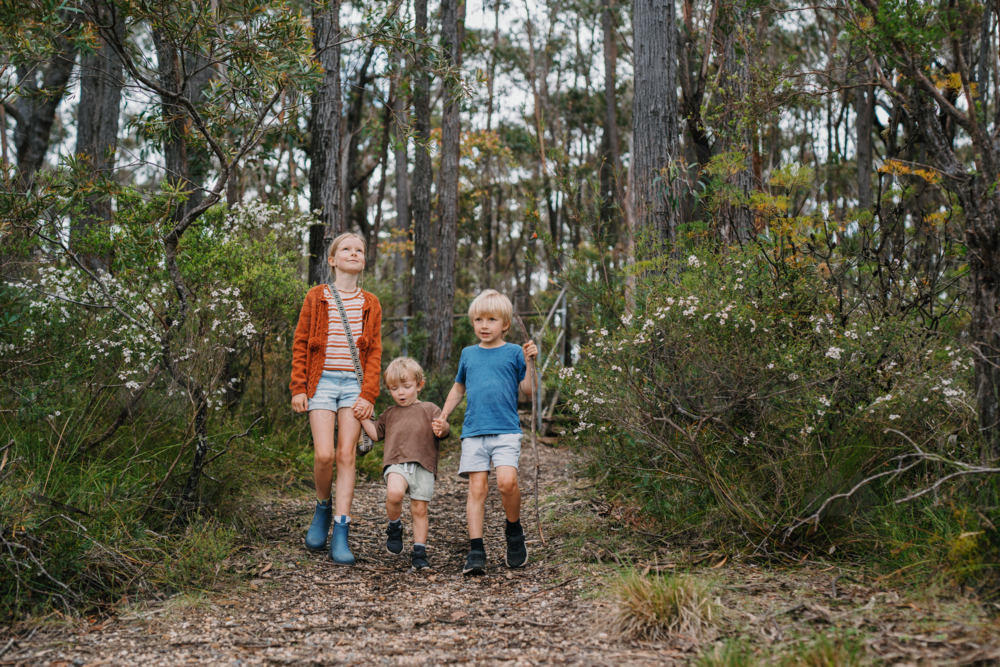 Children exploring Australian Bushland walking down trail together - Australian Stock Image