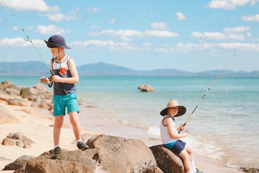 Children fishing on the beach at Cape Gloucester in the Whitsundays - Australian Stock Image