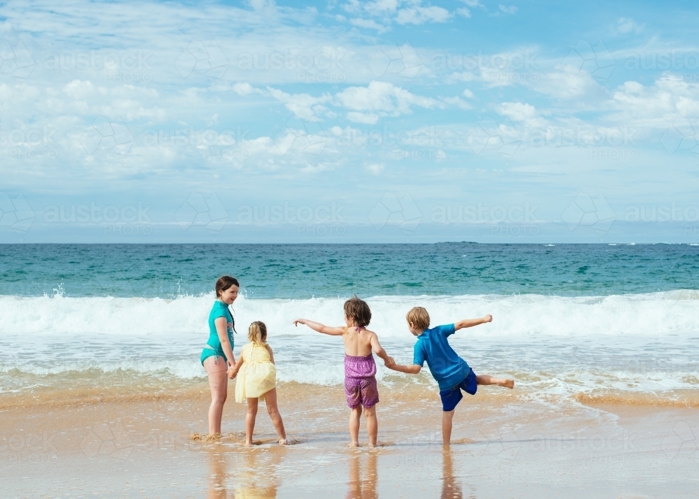 Children holding hands at the beach - Australian Stock Image