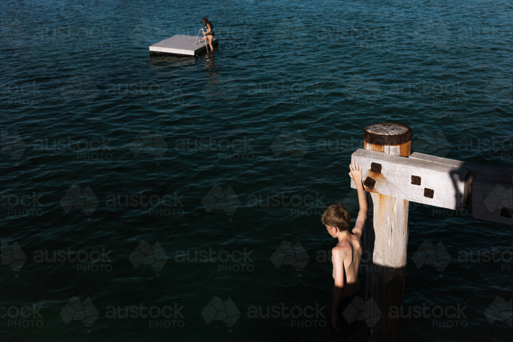 Children on pontoon and jetty in late summer sun - Australian Stock Image