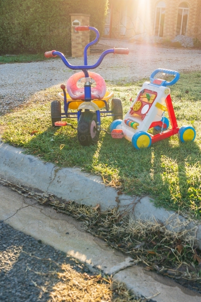 Children's toys sitting on the roadside on early morning sunshine - Australian Stock Image