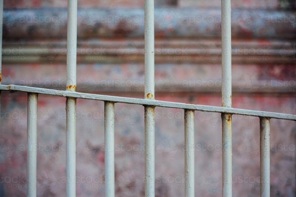 Chipped paint wall behind metal railing - Australian Stock Image