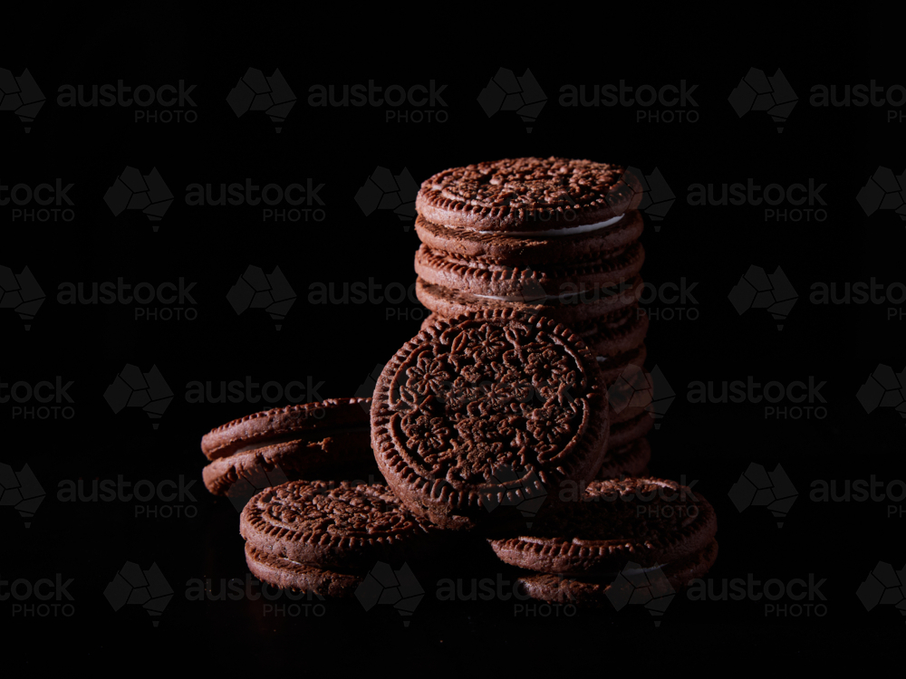 Chocolate cream biscuits on black background - Australian Stock Image