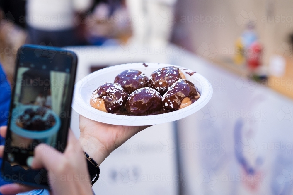 chocolate cream puffs getting photographed - Australian Stock Image