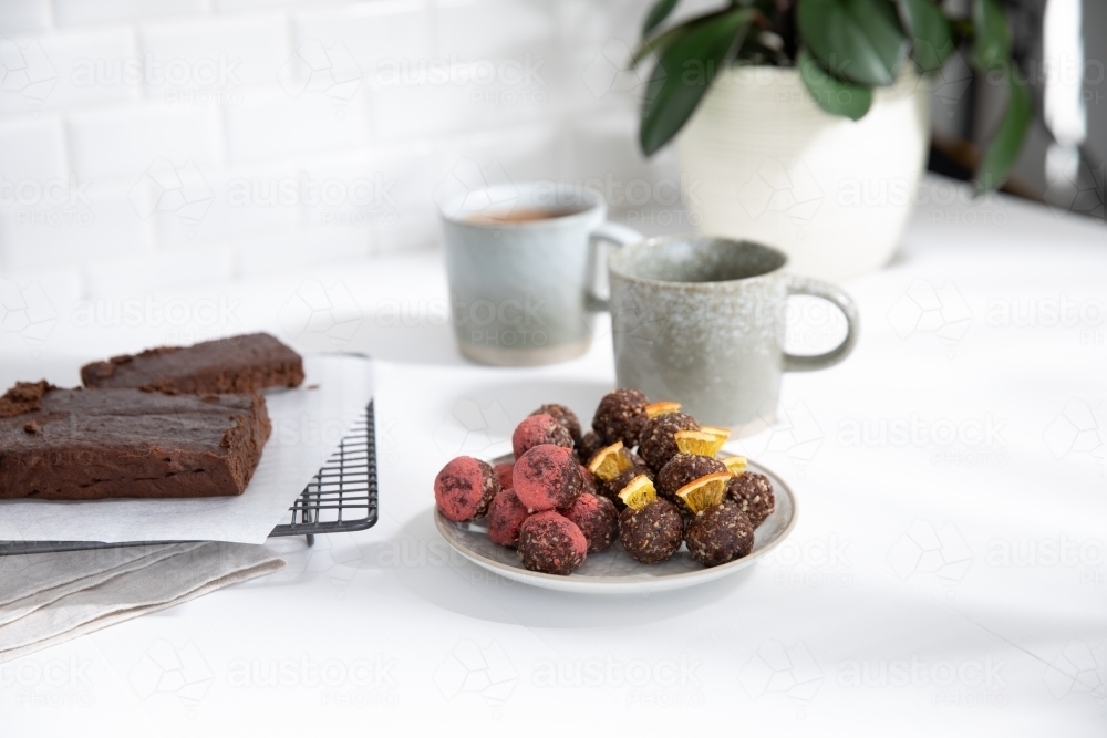 Chocolate protein balls on a white kitchen bench - Australian Stock Image