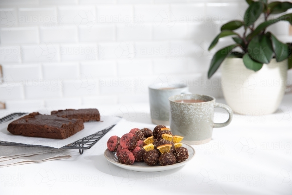 Chocolate protein balls on a white kitchen bench - Australian Stock Image