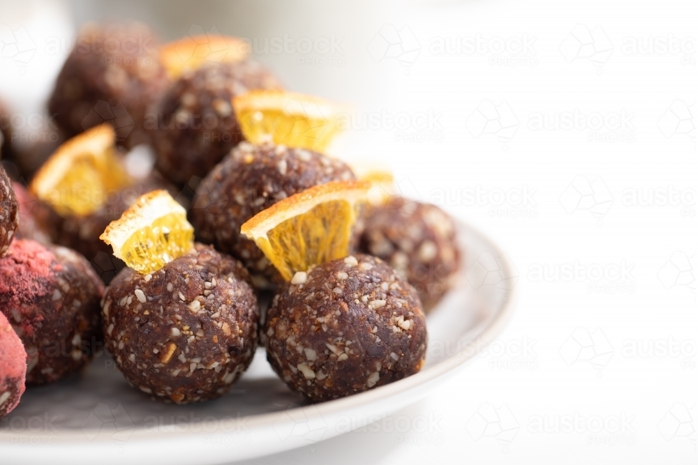 Chocolate protein balls on a white kitchen bench - Australian Stock Image
