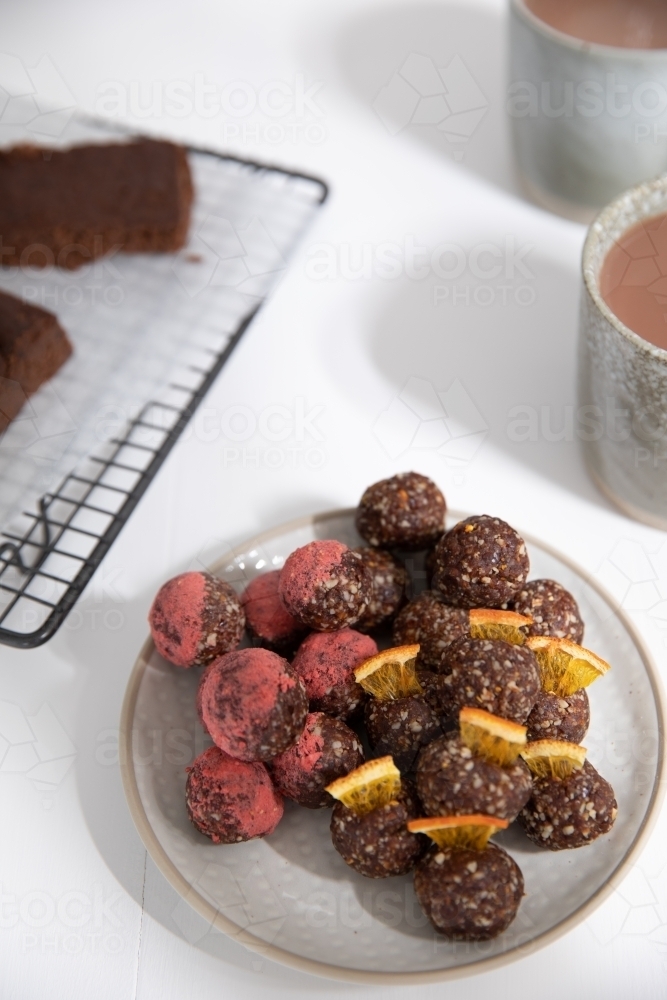 Chocolate protein balls on a white kitchen bench - Australian Stock Image