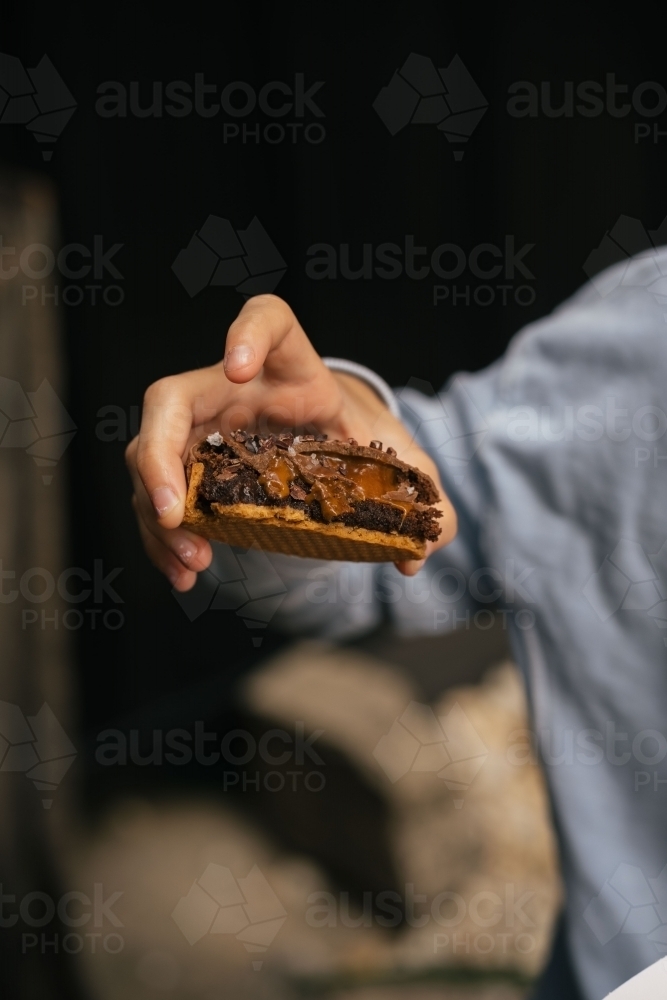 Chocolate tart in hand - Australian Stock Image