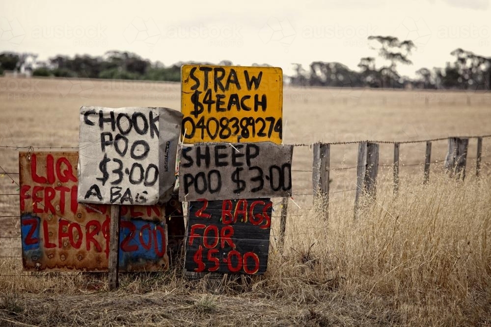 Chook and sheep poo for sale signs beside country road - Australian Stock Image