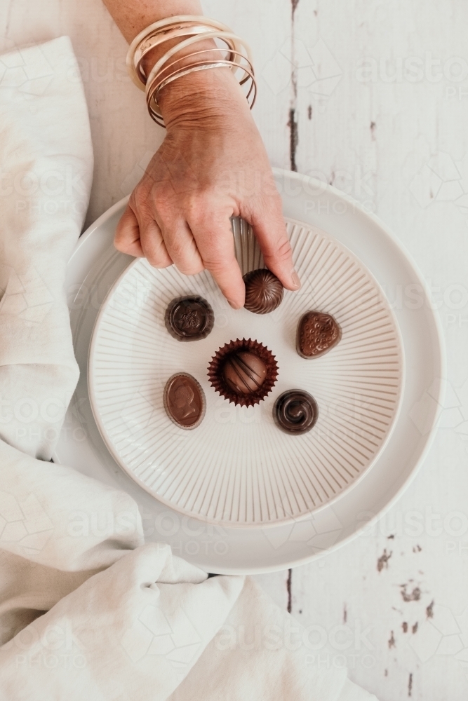 Choosing chocolates on a plate. - Australian Stock Image