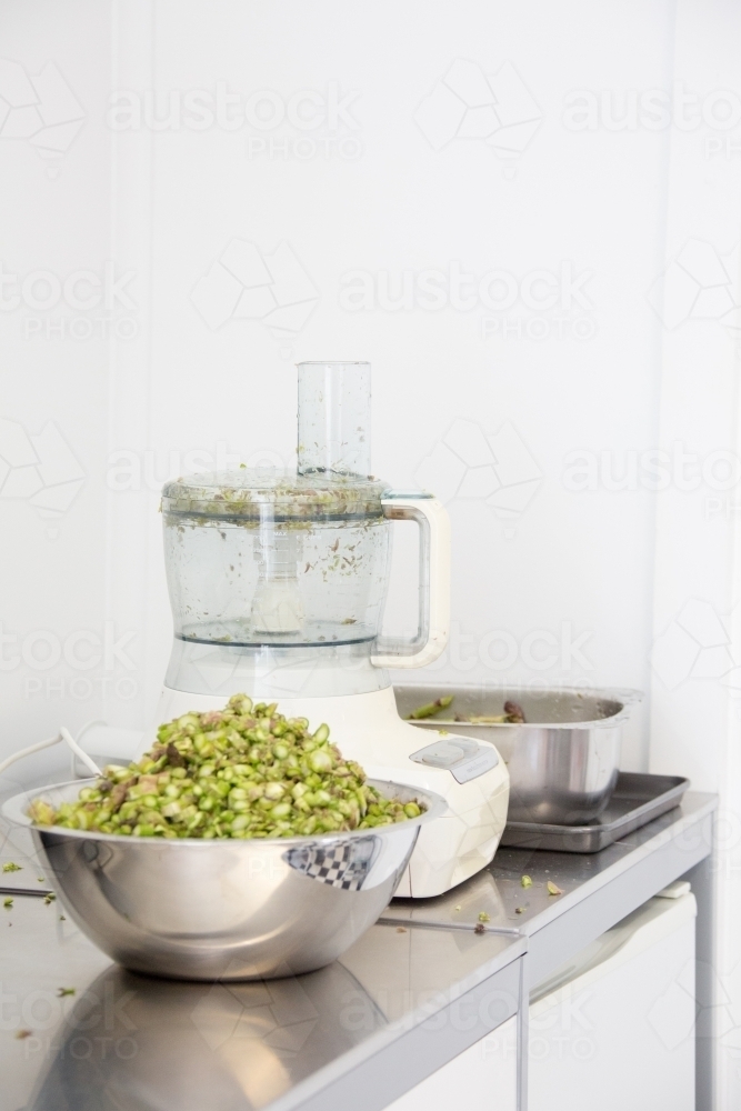 chopped up asparagus with food processor in background - Australian Stock Image