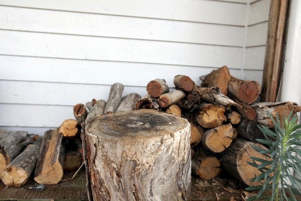 Chopping block and pile of firewood outside - Australian Stock Image