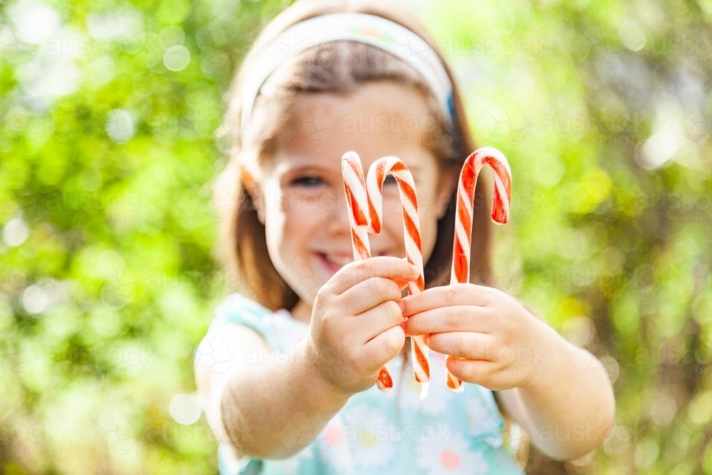 Christmas candy canes in child's hands - Australian Stock Image