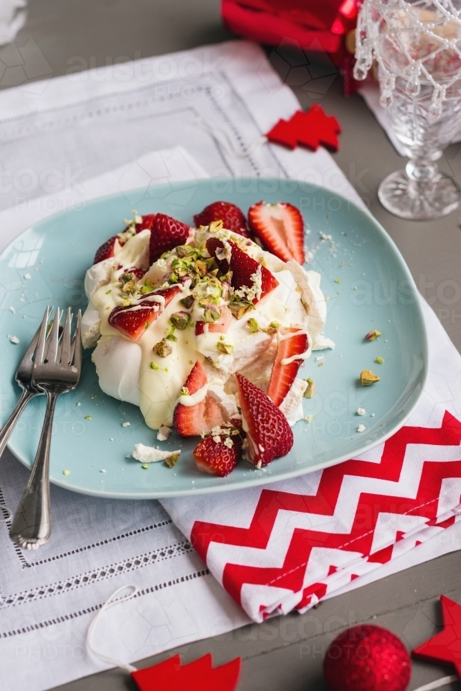 christmas dessert, single pavlova xmas dessert on a blue plate, with strawberries, and cream - Australian Stock Image