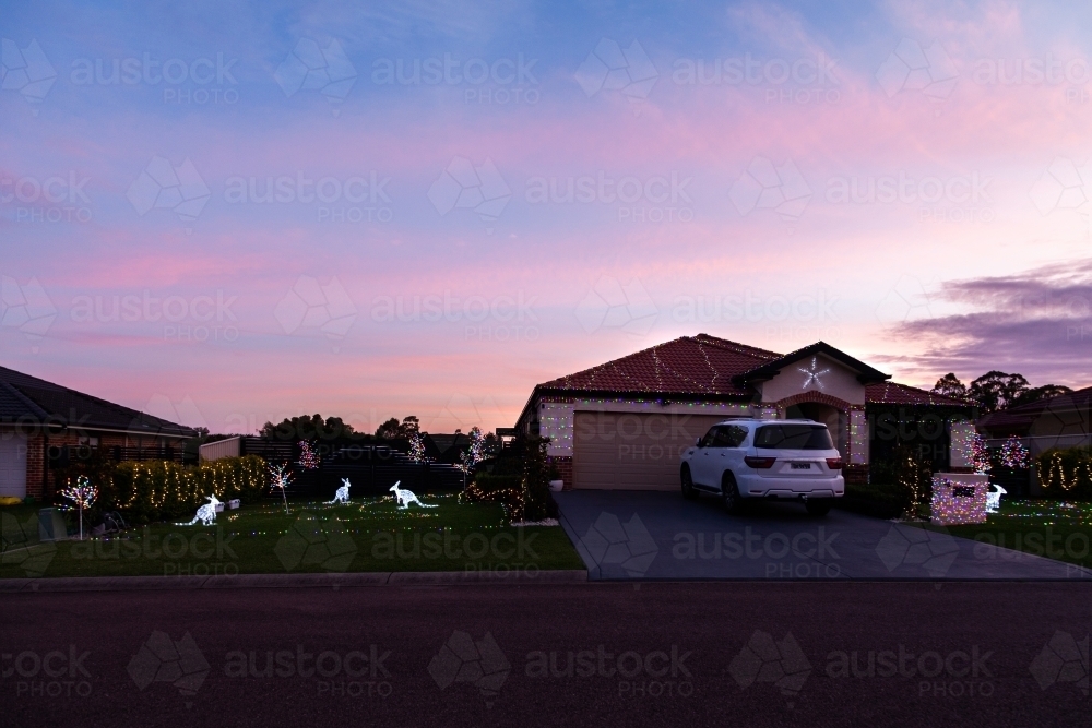 Christmas lights on a Aussie house at dusk with kangaroos in the display - Australian Stock Image