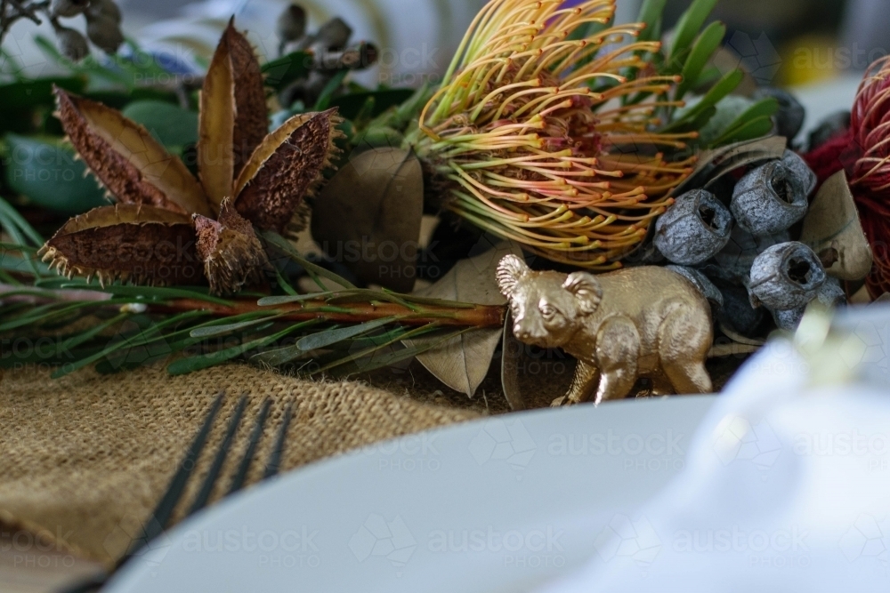 Christmas table setting with native flowers and gold koala ornament - Australian Stock Image