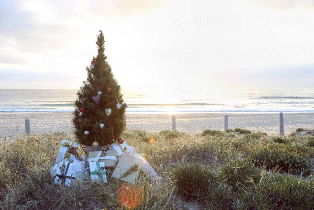 Christmas tree with presents on beach at sunrise - Australian Stock Image