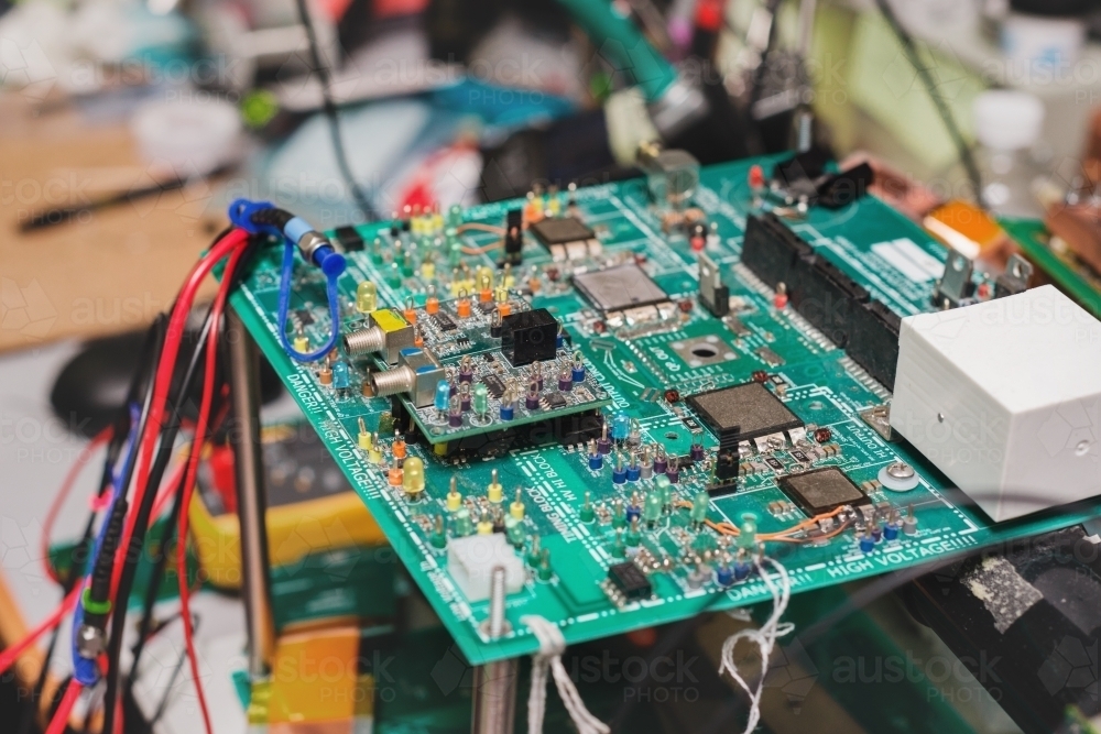 circuit board in messy workshop - Australian Stock Image