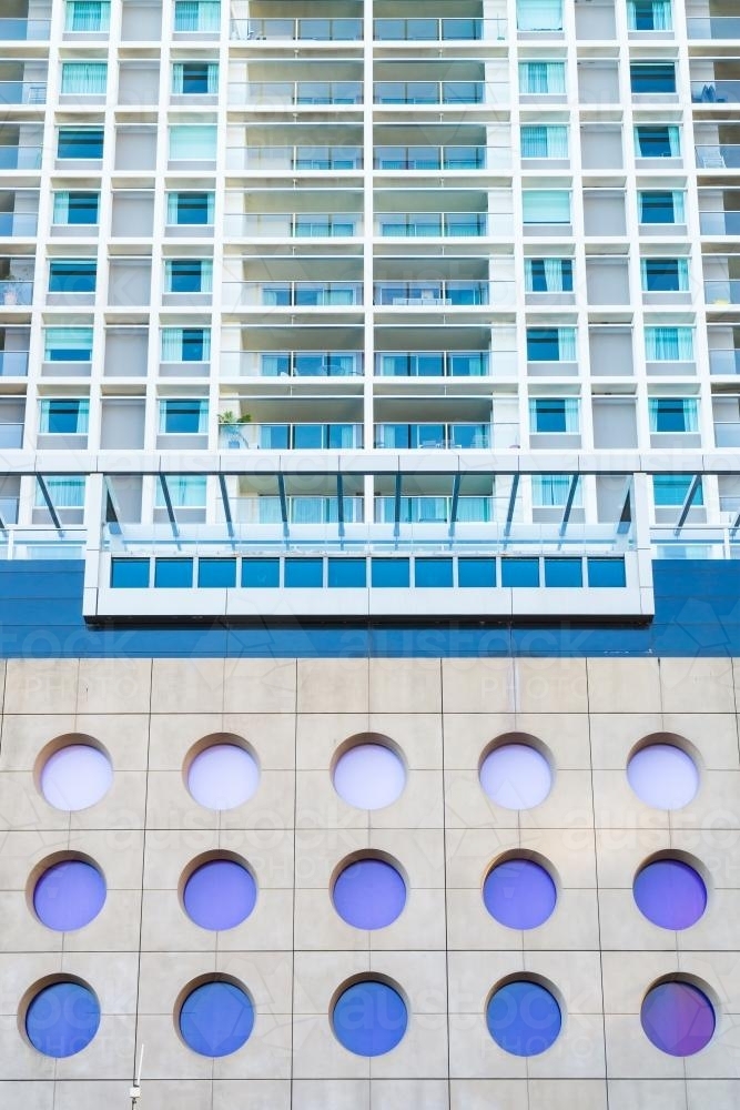 Circular windows and concrete on the side of a tall  building - Australian Stock Image