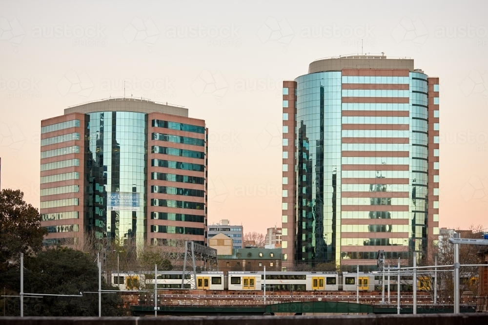 City buildings on dusk with train passing by - Australian Stock Image