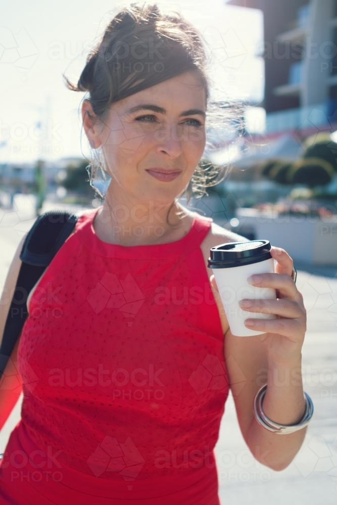 City office worker with coffee on her way to work - Australian Stock Image