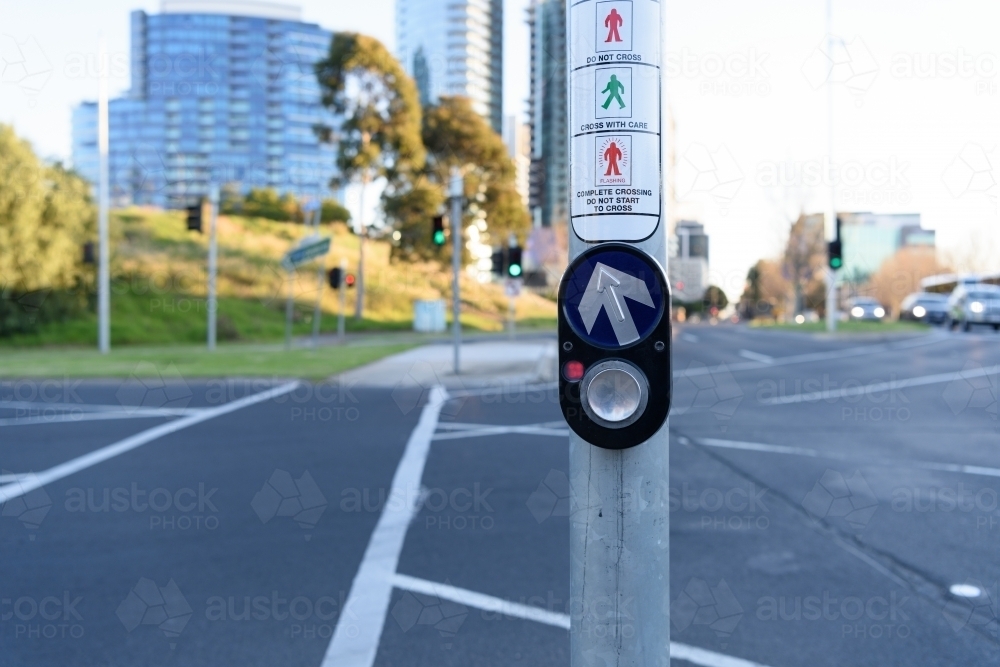 City traffic concept: Pedestrian press to go button at intersection, urban background - Australian Stock Image