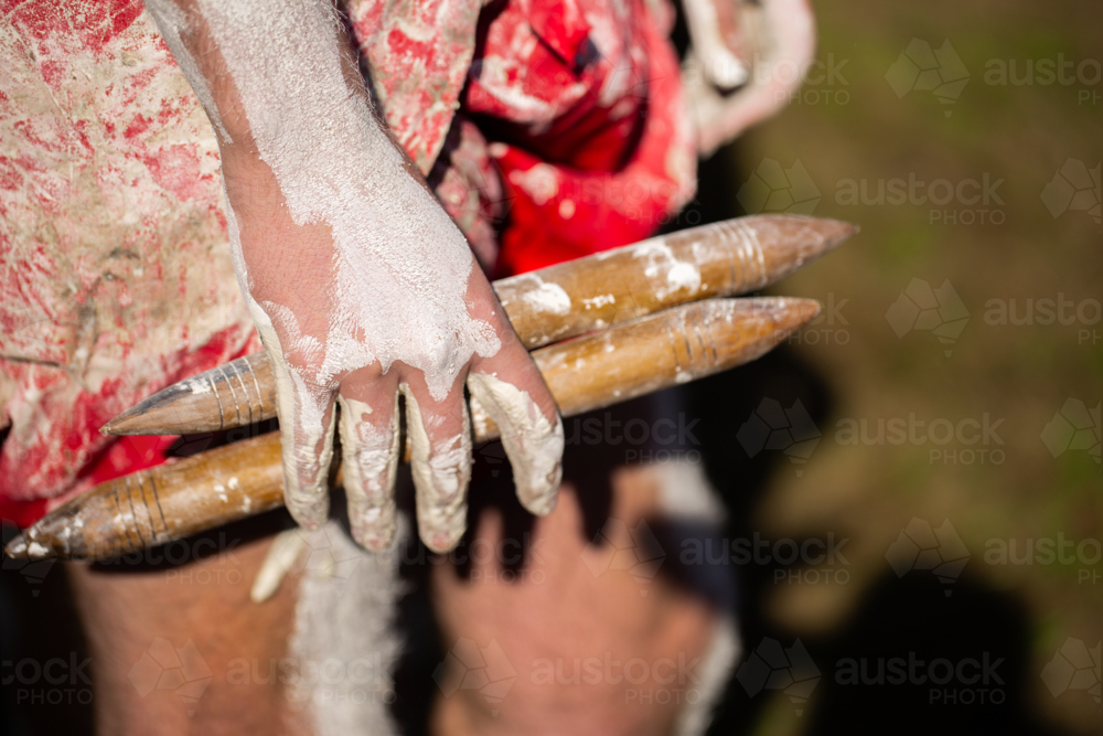 Clap sticks held in hand of aboriginal dancer at NAIDOC celebration - Australian Stock Image