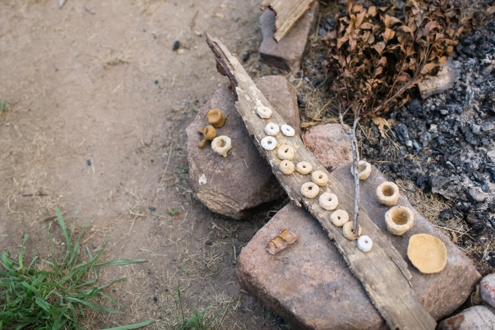 Clay circles drying beside fire - Australian Stock Image