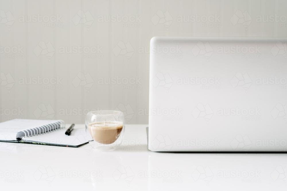clean white desk with laptop, diary and coffee - Australian Stock Image