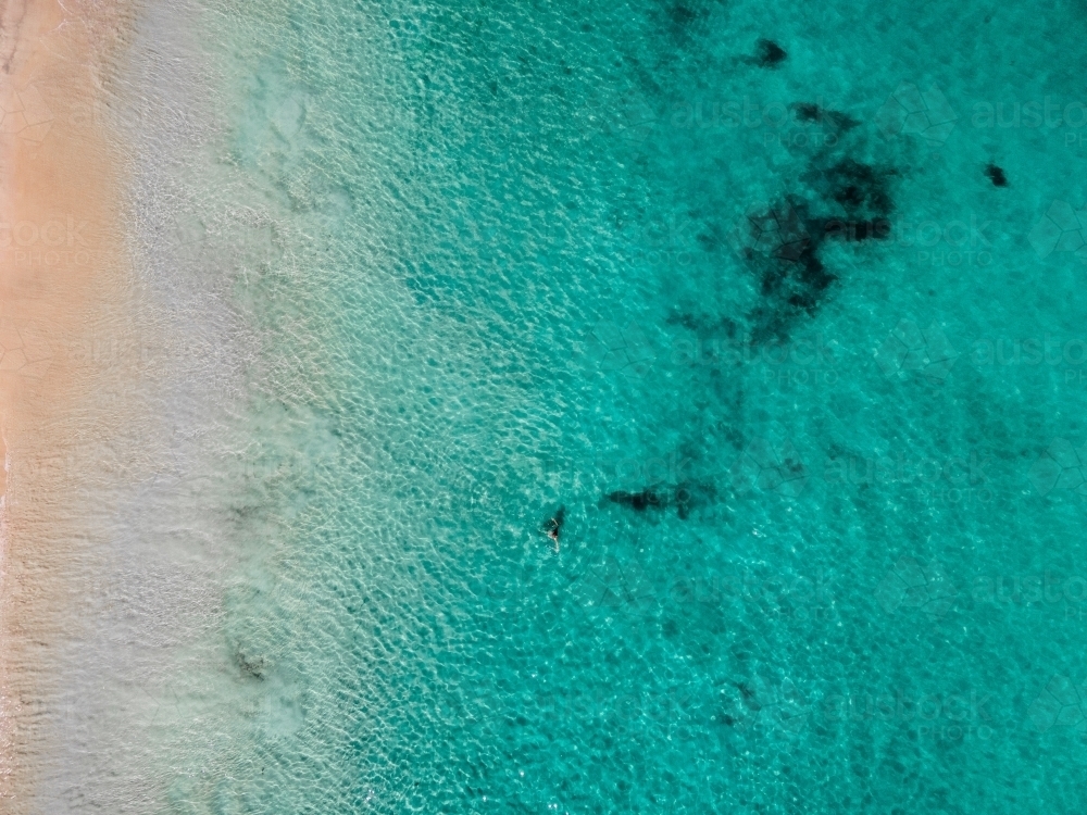 Clear aqua water against sandy shore - aerial view - Australian Stock Image