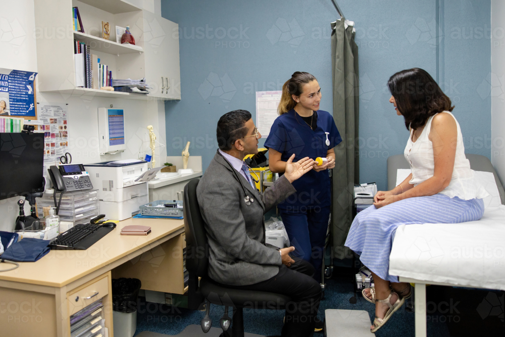 Clinical nurse handing out specimen container to senior patient - Australian Stock Image