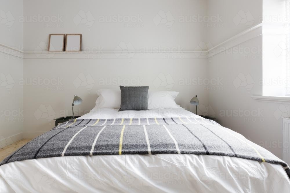Cloose up of grey woolen throw rug on luxury guest bed in Australian apartment - Australian Stock Image